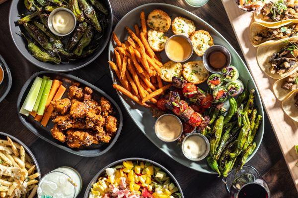Menu items featuring the sharing platter, The Sampler, Pan-Roasted Shisito Peppers, The Taco Platter, and Hot Honey Sweet Potato Fries.